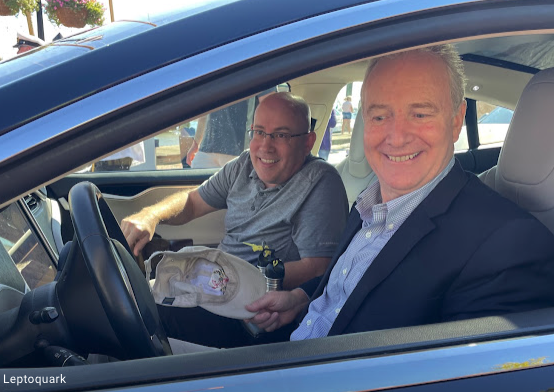 two men smiling in an electric vehicle